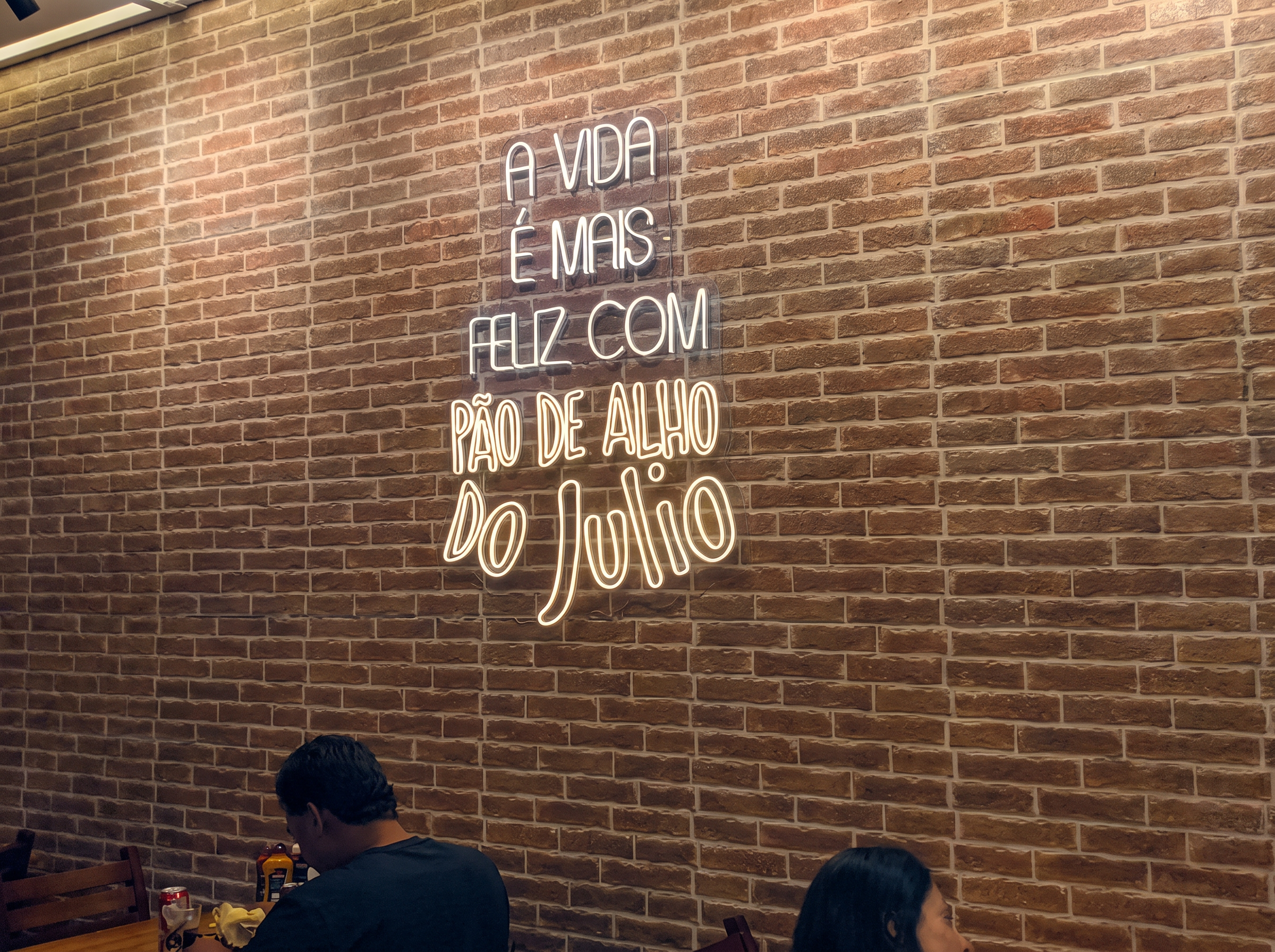 Ambiente com letreiro neon do Pão de Alho do Julio